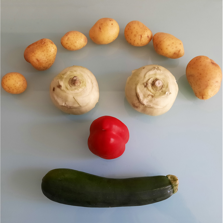 Verschiedenes Gemüse, zusammengestellt als lachendes Gesicht