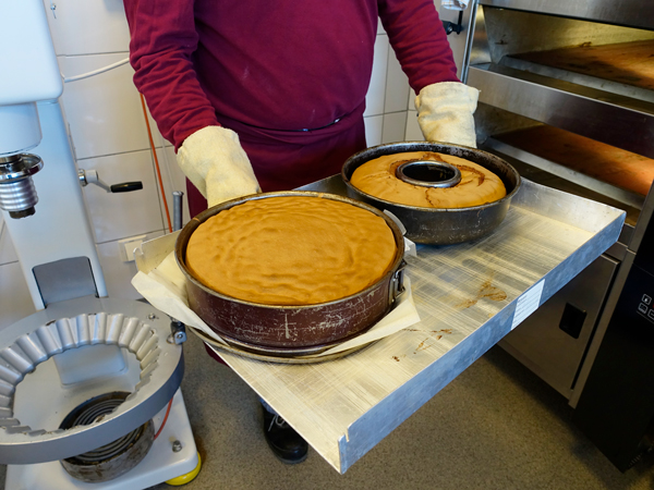 In der Backstube der Alexianer Klostergärtnerei werden fertig gebackene Kuchen aus dem Ofen geholt.