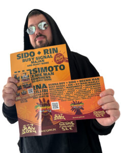 Doc Köllewood mit Plakat und Flyer für Summerjam 2024